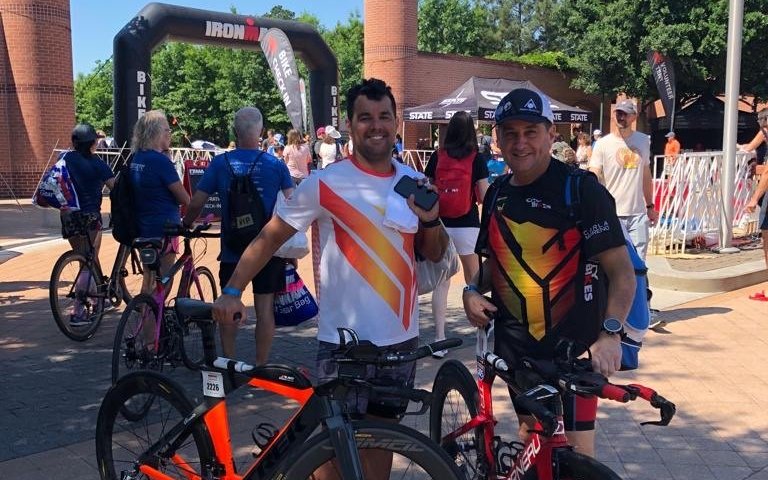 Dois atletas com as bikes no bike check-in de um IRONMAN
