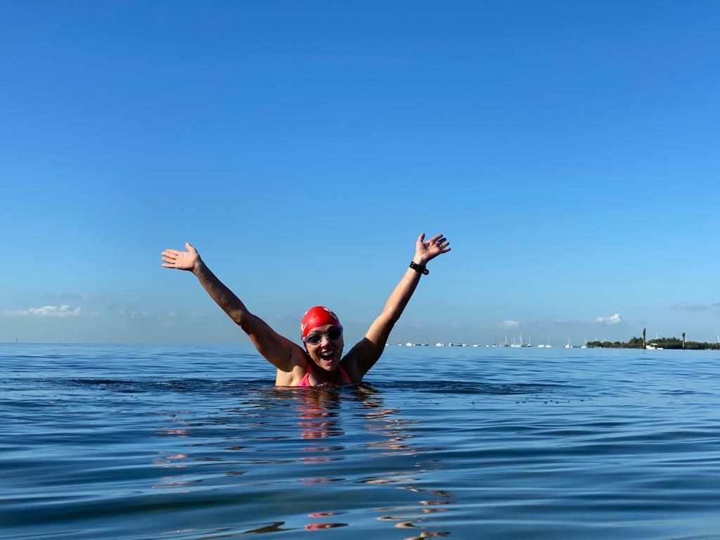 Carla Moreno comemora no mar, de braços abertos, durante treino de natação em Miami