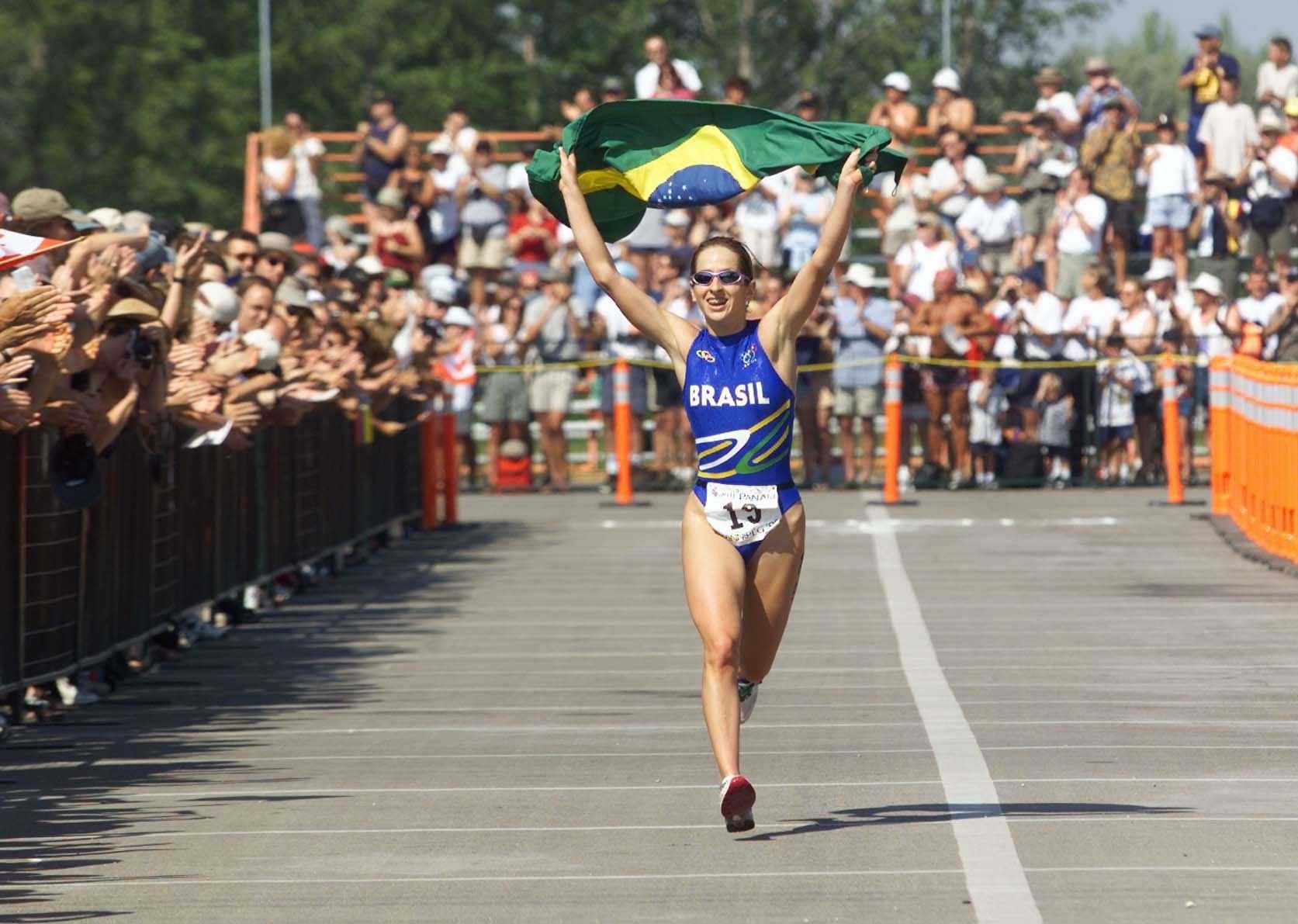 Carla Moreno cruza a linha de chegada com a bandeira do Brasil nos Jogos Pan-Americanos de Winnipeg, em 1999